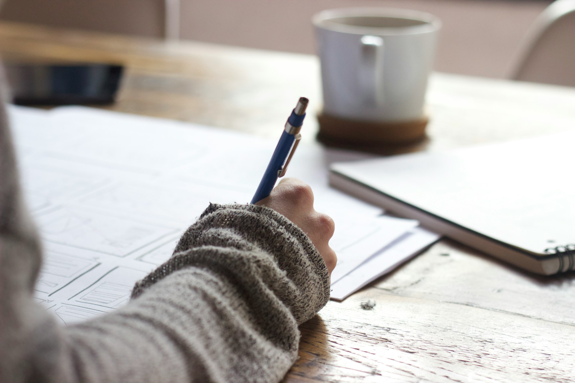 Photo by Unseen Studio on Unsplash. Woman writing out a business trategy. theobmcircle.com